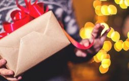 Holding holiday gift box with red tie