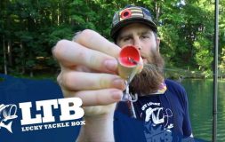 Man holding a red mouth bait in his hands