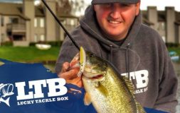 Man holding fish looking at her wearing ltb hoodie