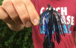 Man in a red shirt holding black swim jig