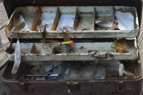 Rusty tackle box with fishing gear inside