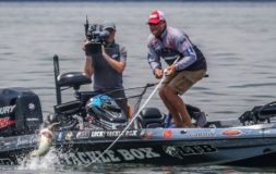 Two men on the boat recording catching fish on the lake