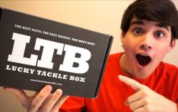Young man holding black lucky tackle box happy